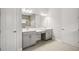 Double vanity bathroom with gray cabinets and a large mirror at 8216 Liebton Pl, Parrish, FL 34219