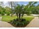 Landscaped front yard with a beautiful palm tree and brick walkway at 849 John Cressler Dr, Seffner, FL 33584