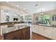 Open kitchen features an island, white cabinets, and a view into the Gathering room at 849 John Cressler Dr, Seffner, FL 33584