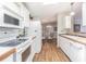 White kitchen features ample cabinetry, microwave, and electric range at 37607 Neukom Ave, Zephyrhills, FL 33541