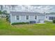Exterior view of the home showcasing the side yard and landscaping at 37607 Neukom Ave, Zephyrhills, FL 33541