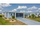 Mobile home with screened porch and landscaped yard at 37607 Neukom Ave, Zephyrhills, FL 33541