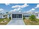 Single-wide mobile home with a screened porch and landscaped yard at 37607 Neukom Ave, Zephyrhills, FL 33541