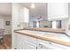 Kitchen features double sink, wood countertops, and white cabinets at 37607 Neukom Ave, Zephyrhills, FL 33541