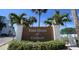 Community sign for Town Shores of Gulfport surrounded by lush greenery and palm trees against a bright blue sky at 2960 59Th S St # 501, Gulfport, FL 33707