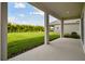 Covered patio overlooks a grassy backyard with lush greenery at 6224 Broad Field Ave, Apollo Beach, FL 33572