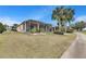 Expansive screened lanai overlooking a beautifully landscaped backyard with mature palm trees at 1007 Emerald Dunes Dr, Sun City Center, FL 33573