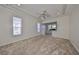 Neutral bedroom featuring a tray ceiling, carpet, and multiple windows for natural light at 1007 Emerald Dunes Dr, Sun City Center, FL 33573