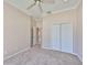 Bright bedroom featuring neutral carpet, vaulted ceilings, crown molding, and a double door closet at 1007 Emerald Dunes Dr, Sun City Center, FL 33573