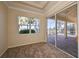 Cozy bedroom with neutral carpet, a window, and sliding doors to a screened lanai overlooking the water at 1007 Emerald Dunes Dr, Sun City Center, FL 33573