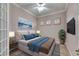 Well-lit bedroom with a comfy bed, coastal wall art, and neutral tones at 1007 Emerald Dunes Dr, Sun City Center, FL 33573