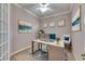Cozy home office with a modern desk setup, a blue accent chair, and a tranquil painting at 1007 Emerald Dunes Dr, Sun City Center, FL 33573