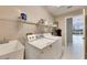 Practical laundry room with a utility sink, washer, dryer, and overhead storage, designed for convenience at 1007 Emerald Dunes Dr, Sun City Center, FL 33573