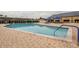 Outdoor pool with brick surround, metal handrails and blue umbrellas over tables and chairs at 1007 Emerald Dunes Dr, Sun City Center, FL 33573