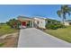Charming single-story home featuring well-manicured landscaping, vibrant red accents, and a convenient covered carport at 218 Glenellen Pl, Sun City Center, FL 33573
