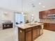 Modern kitchen with granite island, stainless steel appliances, and dark wood cabinets at 1953 Nature View Dr, Lutz, FL 33558
