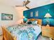 Bedroom with teal accent wall, wood bed frame, and tropical bedding at 1953 Nature View Dr, Lutz, FL 33558