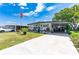 Single-wide manufactured home with carport and landscaped yard at 5316 Comanche St, Zephyrhills, FL 33542