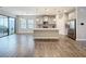 Bright open kitchen area with gray cabinets, stainless steel appliances, and wood-look tile flooring at 12411 Triple Creek Blvd, Riverview, FL 33579