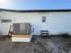 Exterior view of the back of the home, featuring a utility door and an AC unit at 116 W Saint Johns Way, Apollo Beach, FL 33572