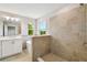 Bathroom featuring a soaking tub, a tiled shower, vanity, and a view of the lush landscape through the windows at 7201 S De Soto St, Tampa, FL 33616