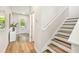 Bright foyer featuring light wood floors, white stairs, and an adjacent entryway, creating an inviting entrance at 7201 S De Soto St, Tampa, FL 33616