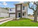 Modern two-story home boasts a blue entry door, small balcony and landscaped front yard at 7201 S De Soto St, Tampa, FL 33616