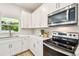 Bright kitchen with white cabinets, stainless steel appliances, a modern range, and ample counter space at 7201 S De Soto St, Tampa, FL 33616
