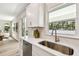Bright kitchen with white cabinets, stainless steel appliances, a modern sink and faucet, and backyard views at 7201 S De Soto St, Tampa, FL 33616