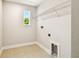 Functional laundry room features tile flooring, a storage shelf, and essential hookups for laundry appliances at 7201 S De Soto St, Tampa, FL 33616