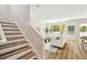 Open-concept living room with wood stairs, a bright window, and comfortable furnishings, offering a modern and inviting atmosphere at 7201 S De Soto St, Tampa, FL 33616