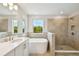 Serene bathroom featuring a tiled shower, soaking tub, and vanity with quartz countertop and great natural light at 7201 S De Soto St, Tampa, FL 33616