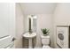 Modern powder room features a pedestal sink, a sleek mirror, and minimalist decor, providing a clean and stylish space at 7201 S De Soto St, Tampa, FL 33616