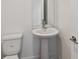 Clean powder room with a pedestal sink, toilet, and modern fixtures at 7201 S De Soto St, Tampa, FL 33616