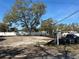 Vacant property is ready for new construction, featuring a large tree and partially fenced perimeter at 7201 S De Soto St, Tampa, FL 33616