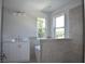 Bright bathroom features a white vanity, tub, and large tiled shower, and leafy views at 7205 S De Soto St, Tampa, FL 33616
