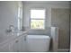 Bright bathroom with double sink vanity, free-standing tub, and large window plus tiled shower at 7205 S De Soto St, Tampa, FL 33616