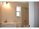 Bathroom featuring a shower-tub combo, a single sink vanity, and a window for natural light at 7205 S De Soto St, Tampa, FL 33616