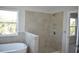 Large tiled shower in neutral tones, plus free-standing tub and window with leafy views at 7205 S De Soto St, Tampa, FL 33616