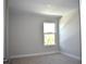 Bright, neutral-toned bedroom with a window, carpet floors, and a clean, modern design at 7205 S De Soto St, Tampa, FL 33616