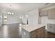 View from the kitchen island overlooking the dining and living area with dark wood-style flooring at 7205 S De Soto St, Tampa, FL 33616