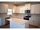 Modern kitchen featuring white cabinets, stainless steel appliances, and a white countertop island at 7205 S De Soto St, Tampa, FL 33616