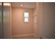 Functional laundry room with tile flooring, a window, and shelving for efficient organization and storage at 7205 S De Soto St, Tampa, FL 33616