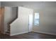 A bright living room with wood floors and stairs, with a window providing natural light at 7205 S De Soto St, Tampa, FL 33616
