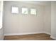 A bright room featuring three windows, wood floors, and neutral walls at 7205 S De Soto St, Tampa, FL 33616
