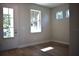A bright room with wood floors, white trim, and ample natural light from a large window and glass paneled door at 7205 S De Soto St, Tampa, FL 33616