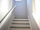 View of the staircase with natural wood treads and white risers and white banister at 7205 S De Soto St, Tampa, FL 33616