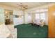 Cozy living room features green carpeting, a comfy sofa, and a view into the kitchen at 116 W Saint Johns Way, Apollo Beach, FL 33572