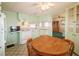 View of the kitchen with light green cabinets, a microwave, and a round dining table at 116 W Saint Johns Way, Apollo Beach, FL 33572