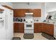 Galley style kitchen with wood cabinets and white appliances at 17539 Balmaha Dr, Land O Lakes, FL 34638